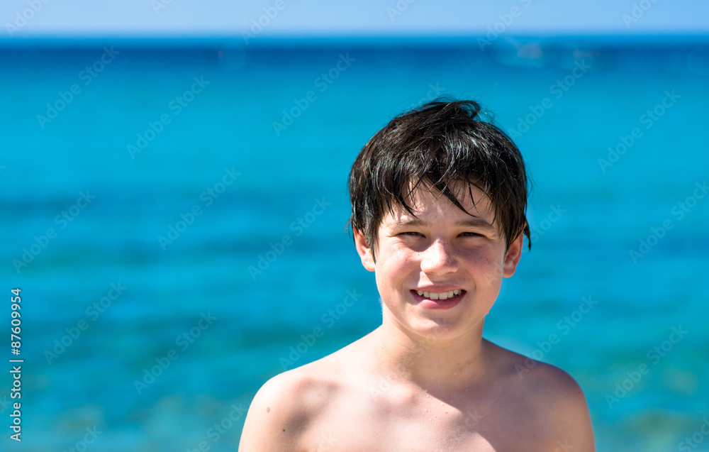 Young boy playing at sea, blue sea background Young boy playing at sea, blue sea background