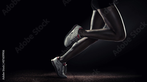 Sports background. Runner. Side view of a jogger legs isolated on black 