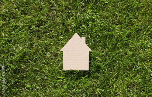 Cardboard house on green grass 