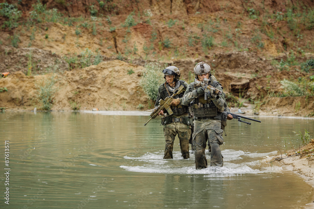 Naklejka premium Military team crossing the river under fire