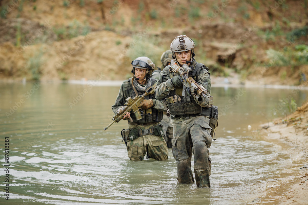 Naklejka premium Military team crossing the river under fire