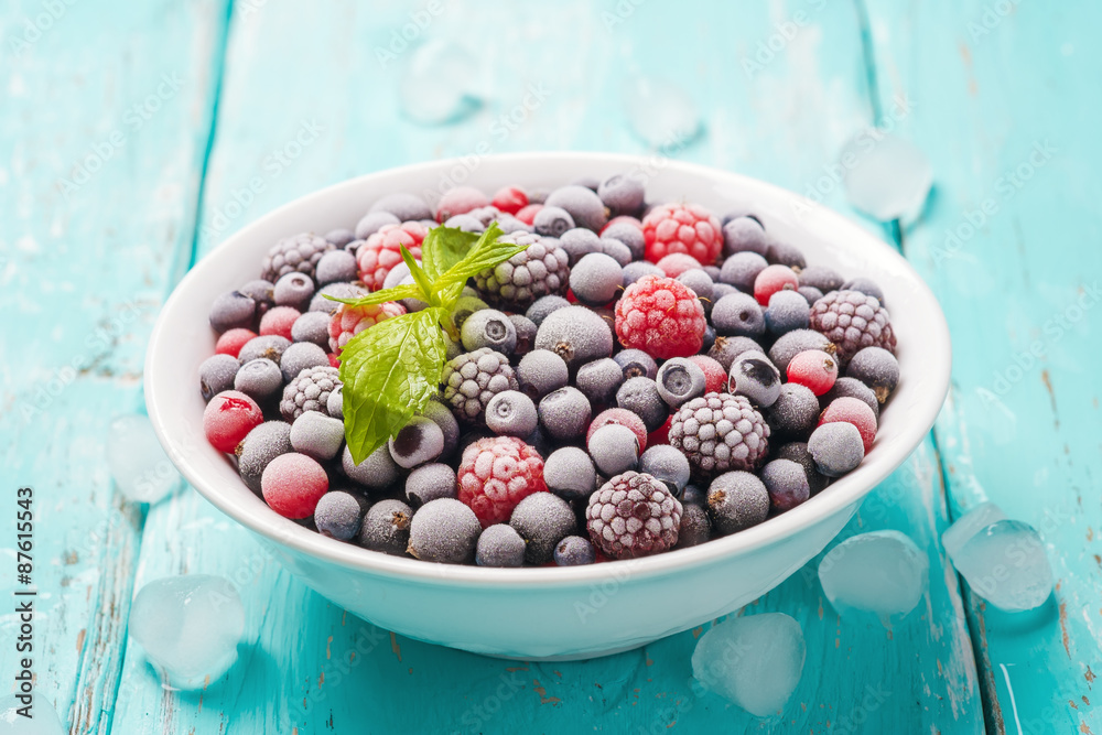 Plate of fresh frozen berries on a turquoise background, closeup Plate of fresh frozen berries on a turquoise background, closeup