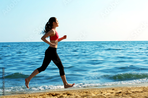 Young woman jogging on beach