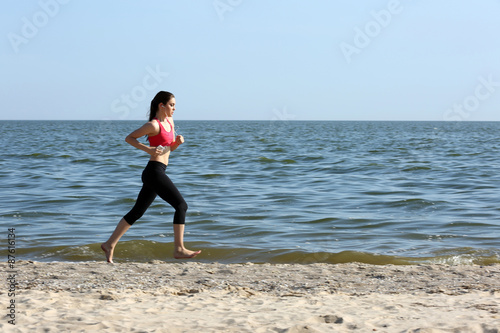 Young woman jogging on beach