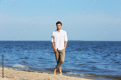 Young man walking on beach © Africa Studio