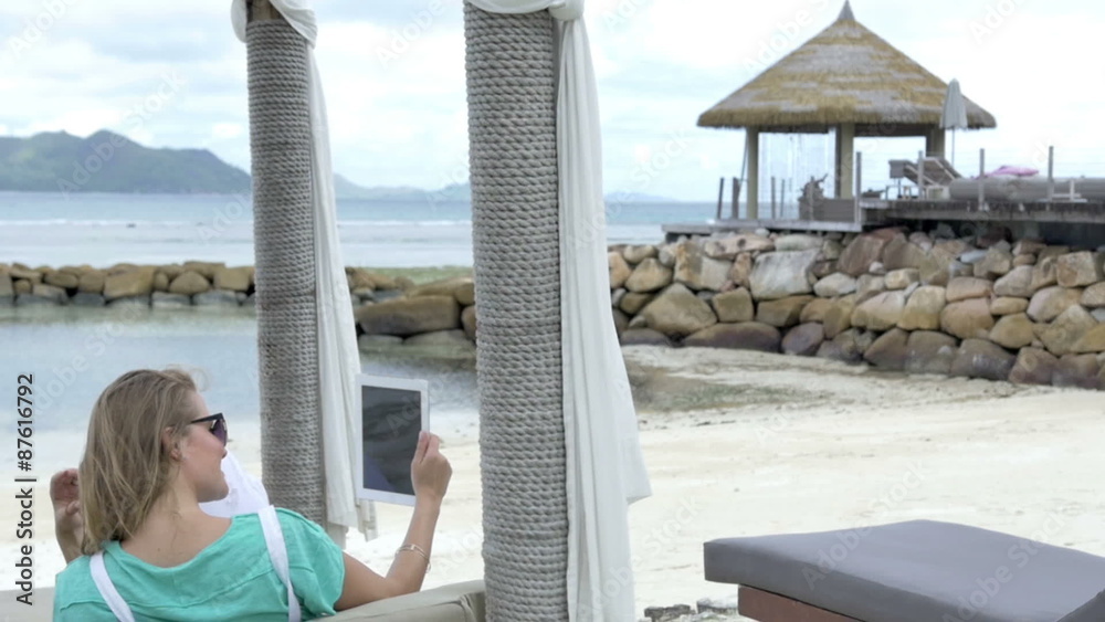 Woman taking selfie with tablet while enjoying vacation in tropical island. Young blonde woman having fun with tablet computer in tropical resort. Woman taking selfie with tablet while enjoying vacation in tropical island. Young blonde woman having fun with tablet computer in tropical resort.