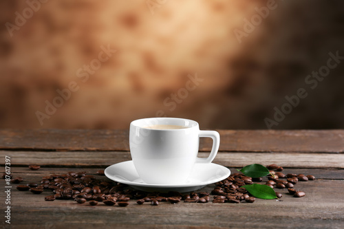 Cup of coffee and beans on blurred background