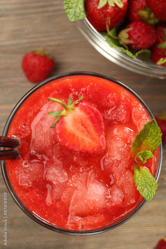 Glass of strawberry smoothie with berries on table close up Glass of strawberry smoothie with berries on table close up