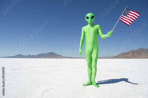Legal (or illegal) alien making a patriotic immigration statement holding an American flag on dramatic lunar landscape