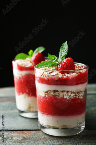 Dessert with fresh strawberry  cream and granola  on wooden table  on dark background