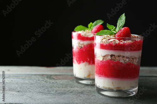 Dessert with fresh strawberry  cream and granola  on wooden table  on dark background