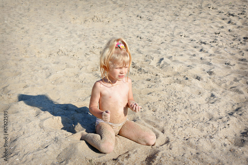 girl a child plays the beach in sand