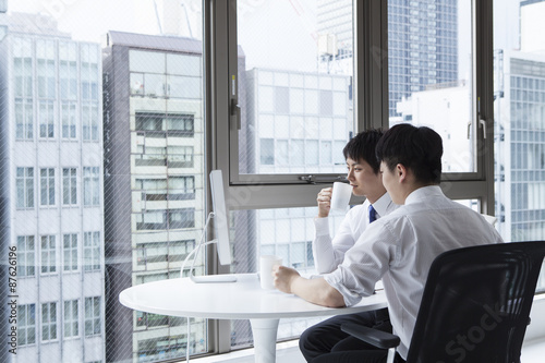 Businessman drinking coffee while looking out the window