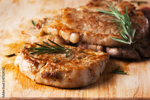 grilled pork chop with rosemary leaf  on wooden board