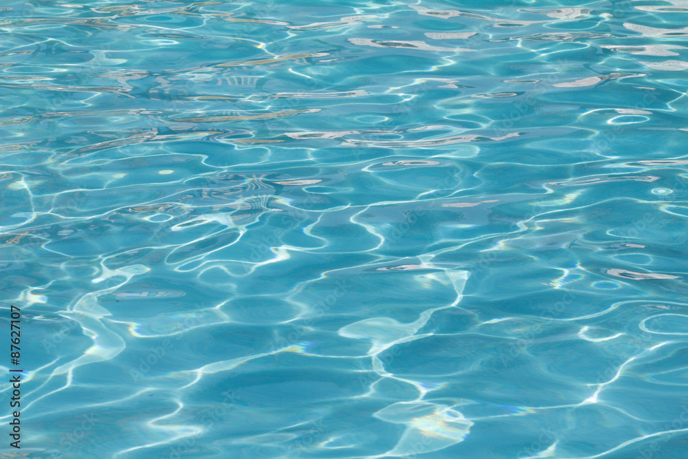 Blue pool water with sun reflections