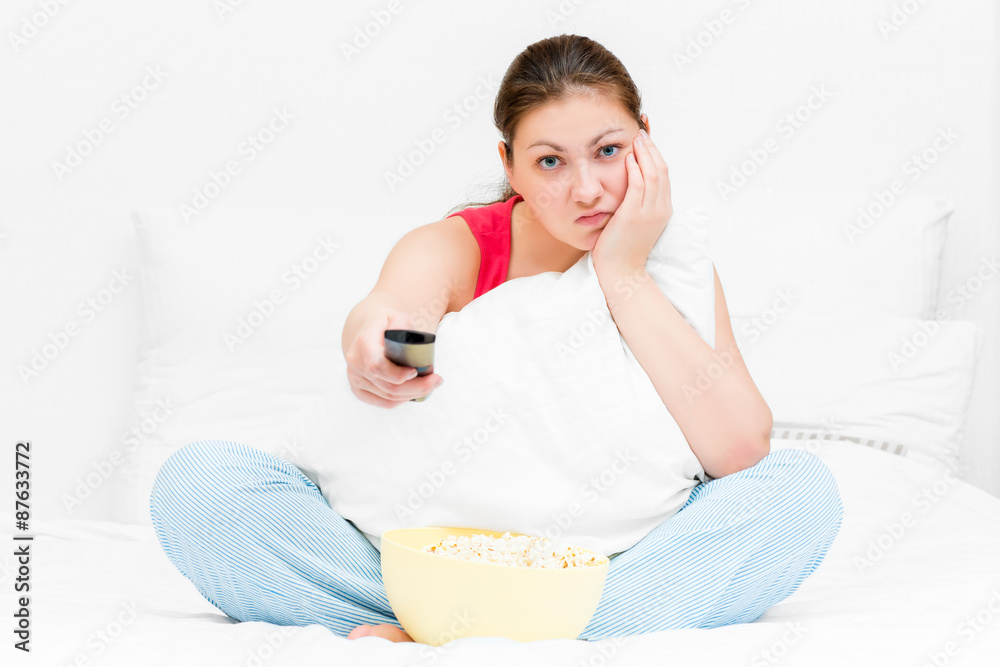 girl in pajamas with remote control TV dissatisfied girl in pajamas with remote control TV dissatisfied