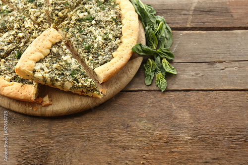 Slices of open pie with spinach on table close up