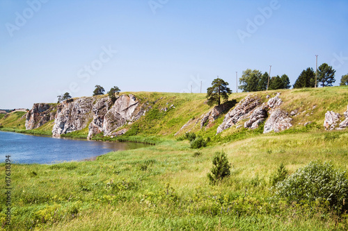 Panoramic view at the rocky shore with a village in the distance