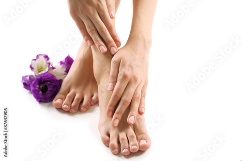 Female feet at spa pedicure procedure with flower isolated on white © Africa Studio