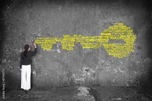 woman writing key with  words on wall