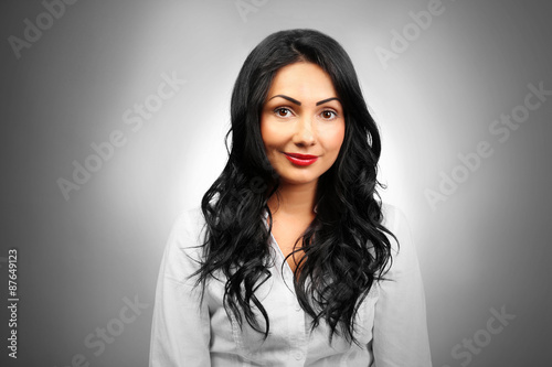 Portrait of pretty brunette on grey background