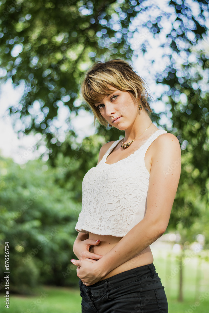 Young Pregnant Woman Standing Outside with Hands on Stomach Young Pregnant Woman Standing Outside with Hands on Stomach