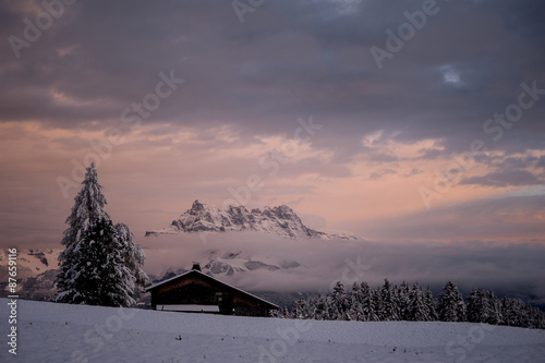 Winter sunset with a log cabin,