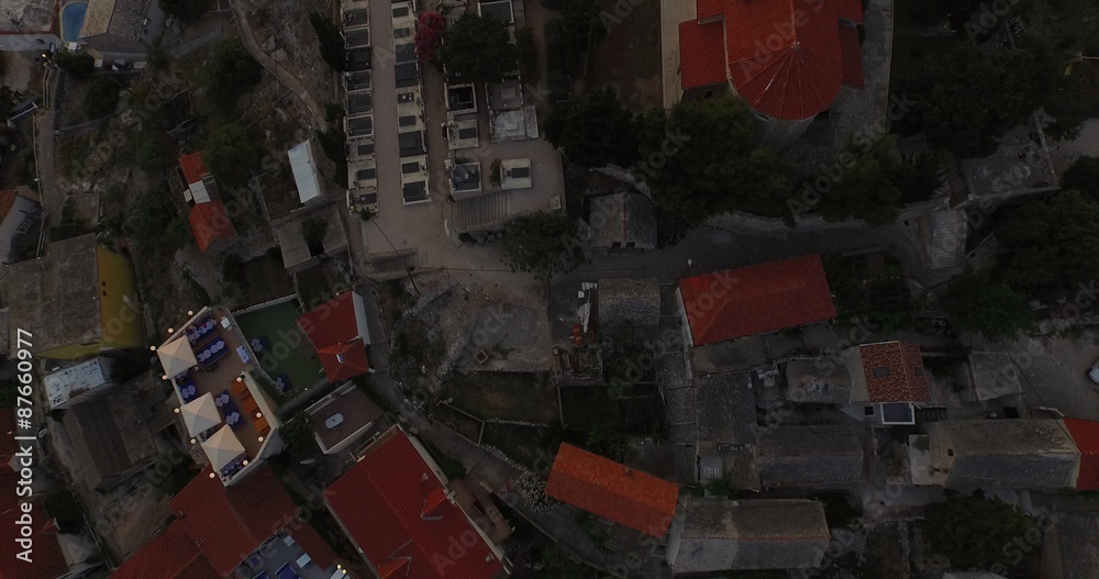 Vista aérea, en planta de ciudad medieval en destino turístico, Croacia. Costa dálmata. Cámara viaja a lo largo de la urbanización. Detalle de las calles y tejados de teja roja.