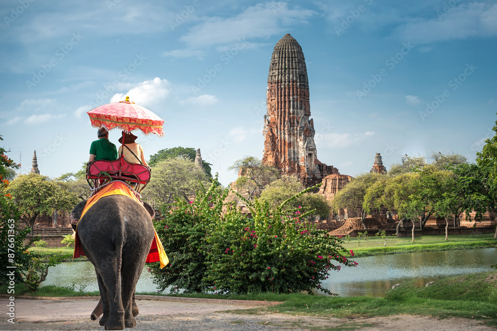 Naklejka premium Turyści na wycieczce na słoniach po starożytnym mieście Ayutaya w Tajlandii