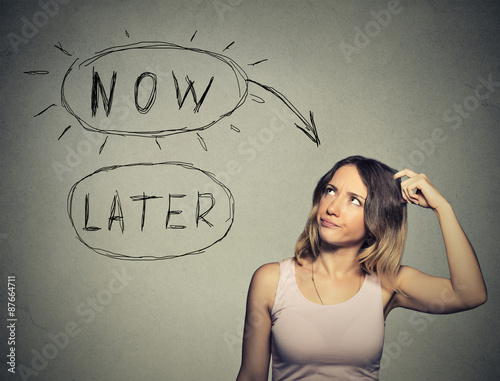 Now or later. Woman thinking scratching head looking up