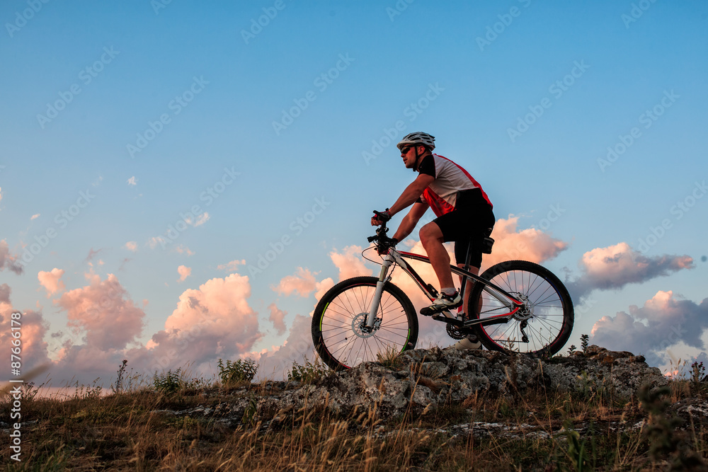 Biker riding on bicycle in mountains Biker riding on bicycle in mountains