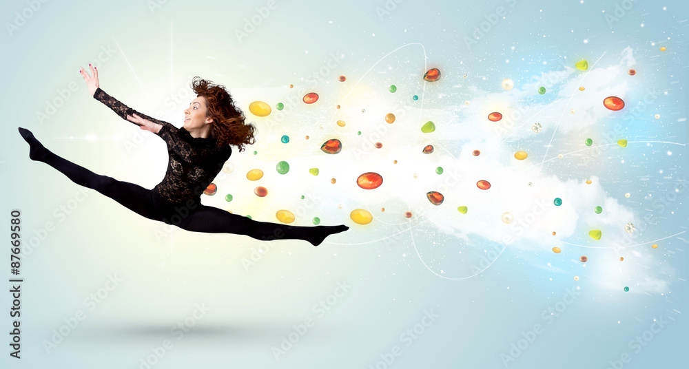 Beautiful woman jumping with colorful gems and crystals on the b Beautiful woman jumping with colorful gems and crystals on the b