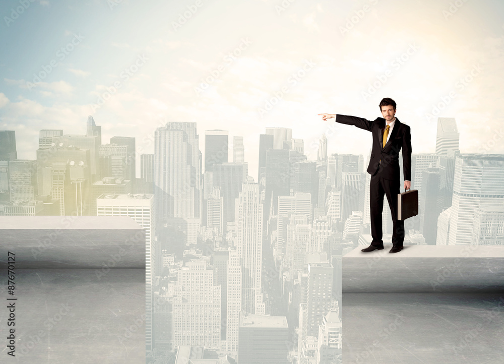 Businessman standing on the edge of rooftop Businessman standing on the edge of rooftop