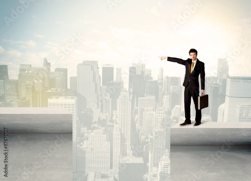 Businessman standing on the edge of rooftop © ra2 studio