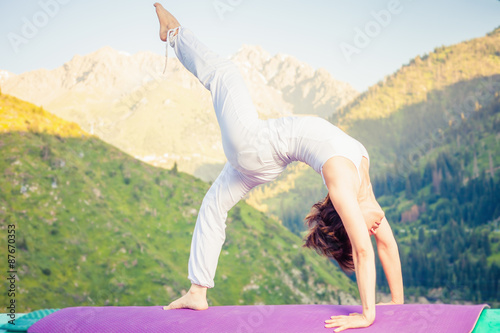 Asian woman doing yoga at mountain