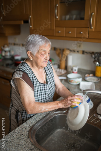Elderly woman washing dishes