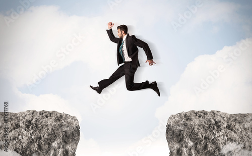 Funny business man jumping over rocks with gap