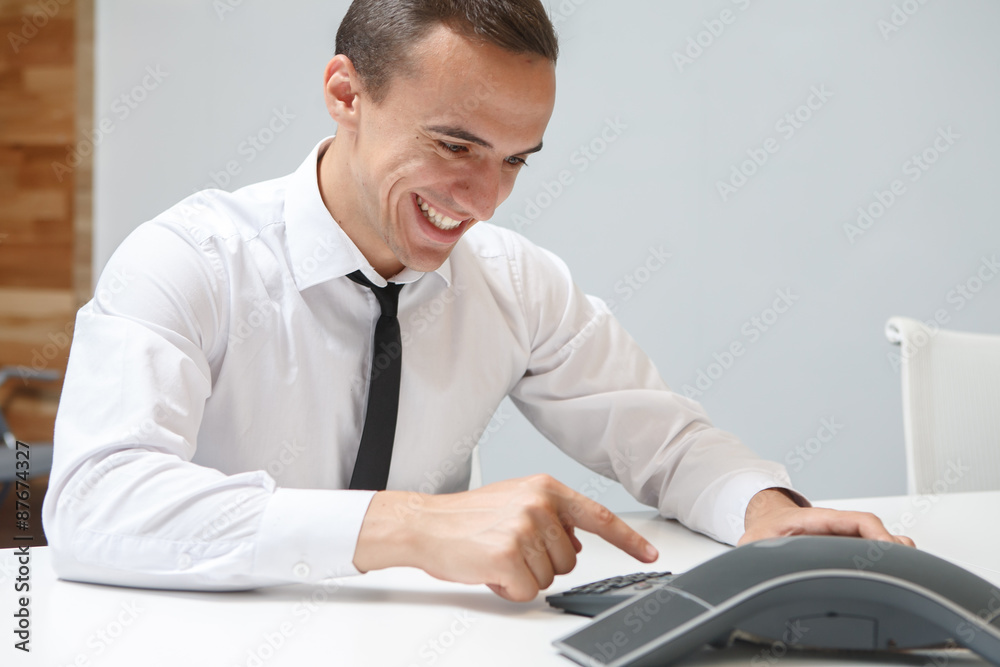 Smiling businessman talks on the conference call in the office Smiling businessman talks on the conference call in the office