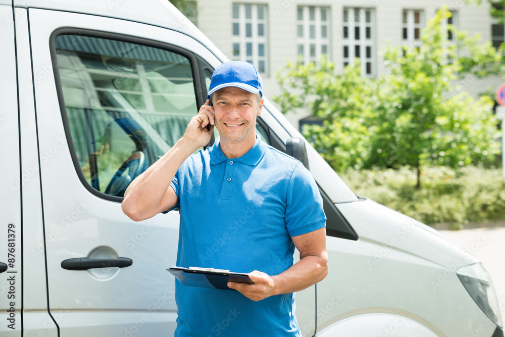 Naklejka premium Worker In Front Of Truck Writing On Clipboard
