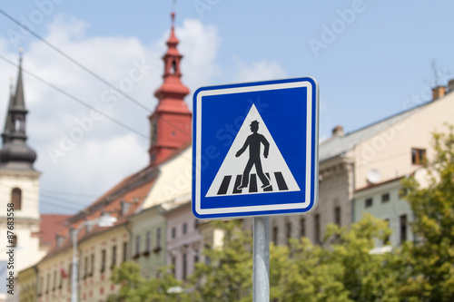Blue zebra crossing sign in a city