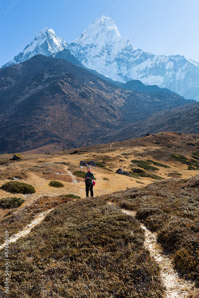 Woman backpacker standing trail Ama Dablam mountain.