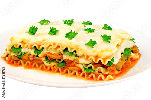 Delicious lasagna slice on a plate, isolated on white background