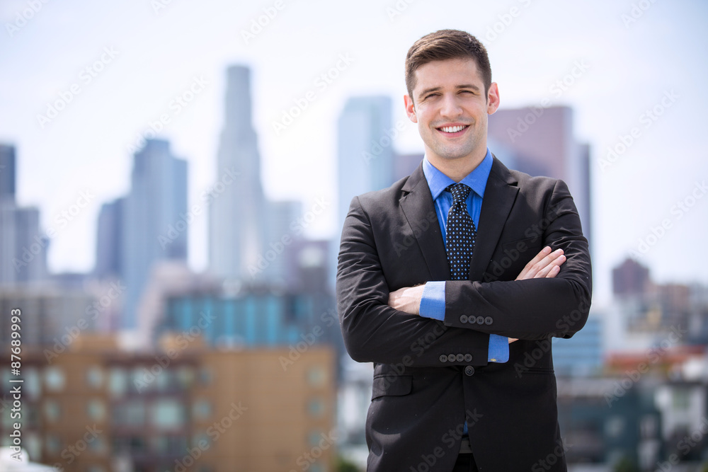 Smiling businessman downtown skyline high rise buildings portrait Smiling businessman downtown skyline high rise buildings portrait