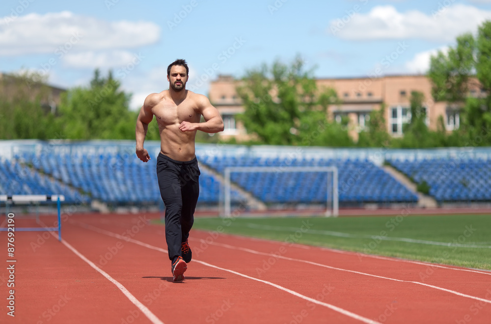 Athlete training. Muscular athlete of the treadmill at the stadium