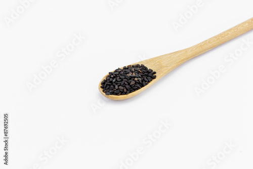 Black Sesame Seeds in wooden spoon isolated on white background