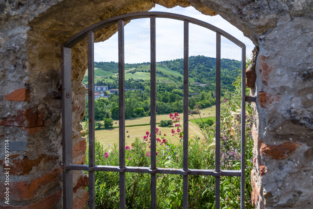 Fototapeta premium country views through Iron grating medieval window