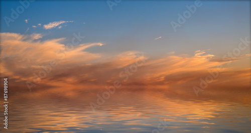 Sunset with clouds reflected in water.