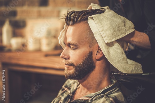 Hairstylist washing client's hair in barber shop