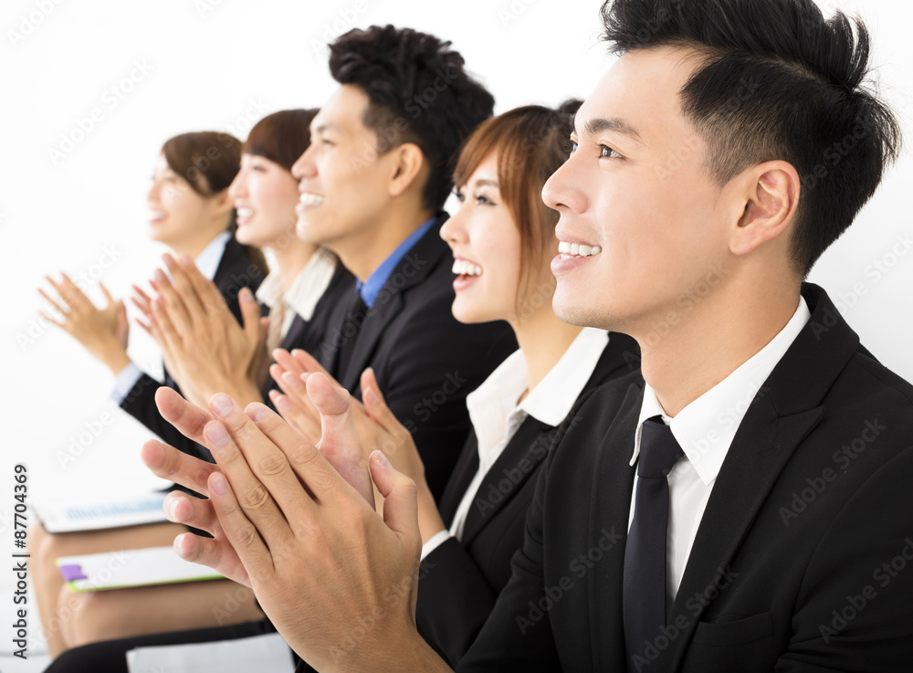 Business people sitting in a row and applauding Business people sitting in a row and applauding