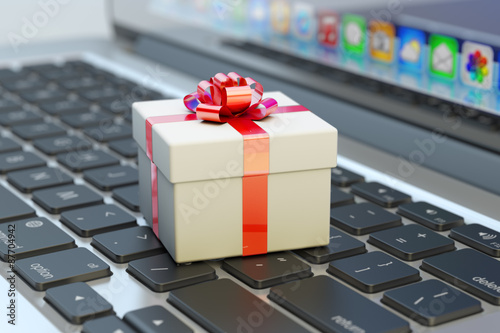 Surprise concept, white gift box with red ribbon bow on computer laptop keyboard macro view